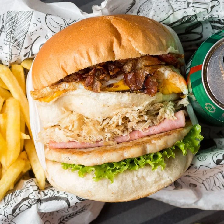 Lanche recheado com frango, queijo, bacon e salada